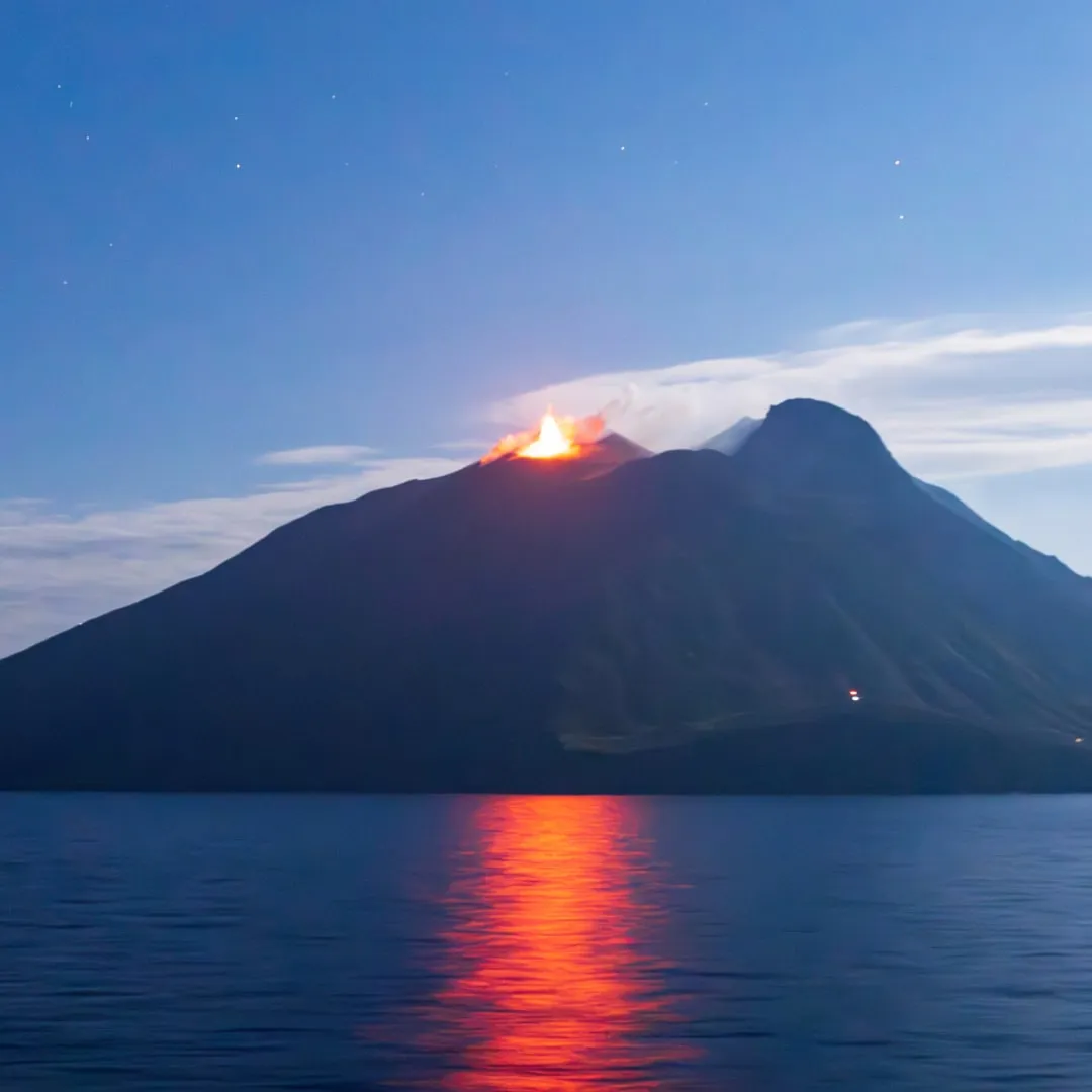 Eruzione dello Stromboli di notte riflessa sul mare